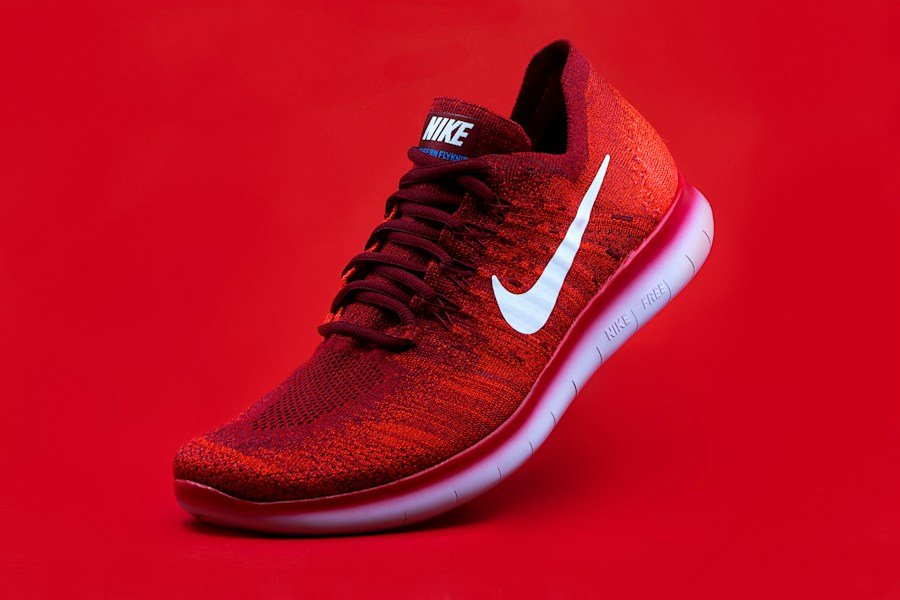 Red performance shoe photographed against a red background